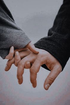 two people holding hands while standing next to each other