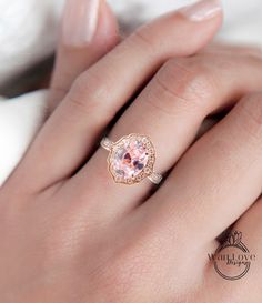 a woman's hand with a pink diamond ring