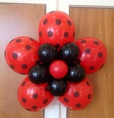 a bunch of balloons that are in the shape of a flower with black and red dots