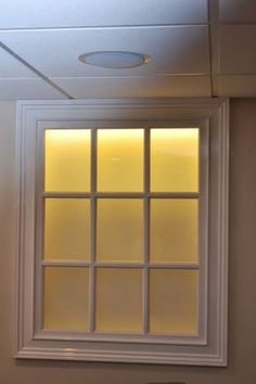 a bathroom with a toilet, sink and window that has frosted glass on it