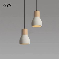 two white lights hanging from a ceiling with the words gyss above them and below it