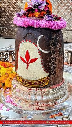 this is a decorated pot with flowers on it's head and the top part of its face