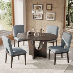 a dining room table with blue chairs around it and a brick wall in the background