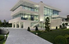 a large white building with lots of windows on it's sides and stairs leading up to the second floor