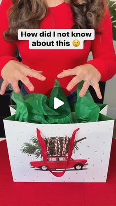 a woman in red shirt holding up a christmas present box with candy canes on it