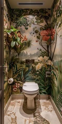 a toilet in a bathroom with tropical wallpaper on the walls and flooring around it