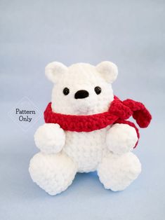 a white teddy bear wearing a red scarf