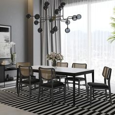 a black and white dining room with striped rug