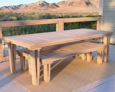 a wooden table and two benches on a patio