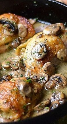 a pan filled with chicken, mushrooms and gravy on top of a table