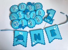 a blue birthday banner with numbers and a dolphin on it, hanging from a string