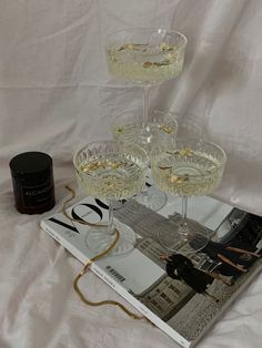 three wine glasses sitting on top of a magazine