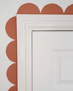 an image of a white door frame with orange circles on the wall in front of it