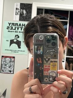 a woman taking a selfie in front of her cell phone with stickers on it