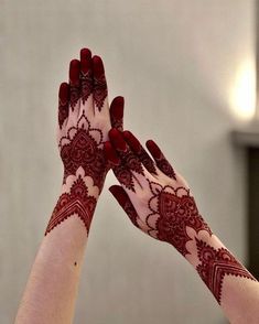 two hands with henna tattoos on their palms