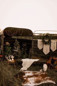 an old truck is parked in the grass with christmas decorations hanging from it's back