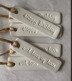 three white tags with words on them that say happy birthday