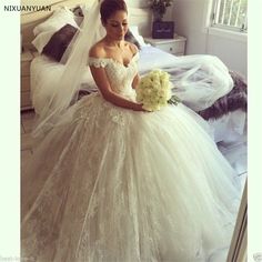 a woman in a wedding dress is sitting on the bed