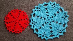 two crocheted doily are laying on the floor, one red and one blue