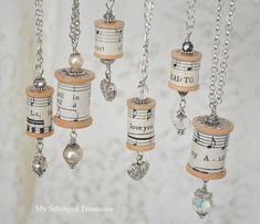 a group of musical notes hanging from chains with beads and charms attached to them on a white background