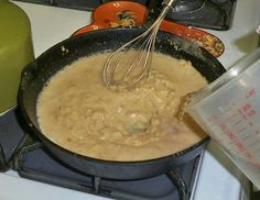 a whisk is being stirred in a skillet on top of the stove