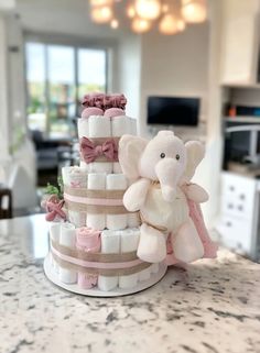 a baby shower cake made out of diapers and stuffed animals on a countertop