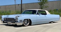 an old white car parked in a parking lot