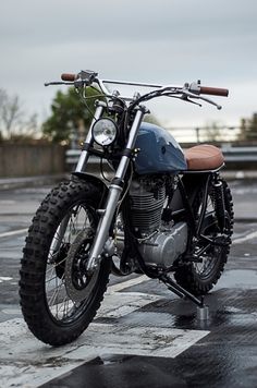 a motorcycle is parked in the parking lot on a rainy day with no one around