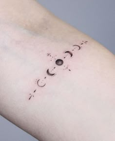 a woman's arm with the moon and stars tattoo on it