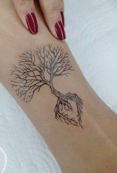 a woman's foot with a tree tattoo on it