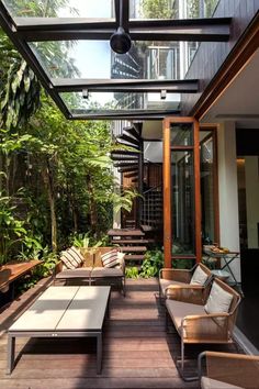 an outdoor living area with couches, tables and stairs leading up to the second floor