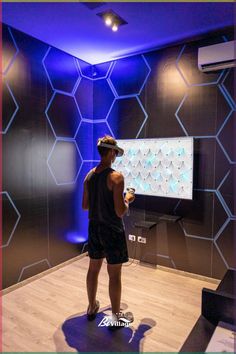 a man standing in front of a projector screen holding a remote and looking at it