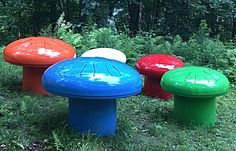 four different colored mushrooms sitting in the grass