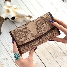 "Introducing our exquisite Women's Western Tooled Leather Wallet, a perfect fusion of style and functionality. Crafted with genuine leather, this wallet showcases a stunning cow skull and sunflower design, adding a touch of rustic charm to your accessory collection. Features: -Length: 8.0\" x Width: 4.0\" -Credit Card Slots: 6 slots in Style #2  - 8 slots in Style #1 -Small change zipper compartment **ATTENTION**- Design #1 is slightly larger and has more card pockets- Design # 2 is a slimmer wa Brown Trifold Rectangular Wallet, Flower Wallet, Tooled Leather Wallet, Cowhide Purse, Genuine Leather Wallets, Flower Skull, Cow Skull, Slim Wallet, Sunflower Design