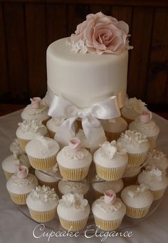 a wedding cake and cupcakes on a table