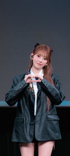 a girl with long hair wearing a black jacket and white shirt is posing for the camera