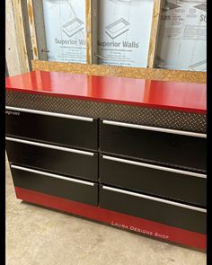 a red and black dresser with two mirrors behind it