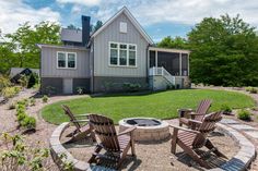 a fire pit surrounded by lawn chairs in front of a house