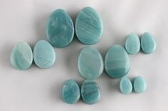 several blue stones arranged on a white surface