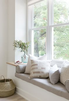 a window seat with several pillows on it