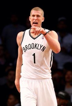 a basketball player holding his fist up in the air and making a gesture with one hand