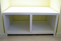 a white shelf sitting in the corner of a room next to a wall with yellow walls