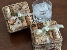 two wine corks wrapped in twine and tied with ribbon, next to a glass of water