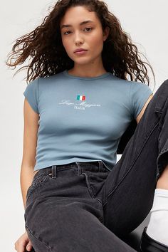 Well-traveled baby tee featuring embroidered Lago Maggiore, Italia graphics across the chest. Designed in a shrunken, slim fit with a crew neckline and mini cap sleeves for a demeur vibe. Features Italia embroidered graphic baby tee Fitted graphic tee Soft & stretchy knit Crew neckline with mini cap sleeves Lago Maggiore, Italia embroidered graphics at the chest Shrunken, slim fit Cropped length Easy pull-over style UO exclusive Content + Care 100% Cotton Machine wash Imported Size + Fit Model i Graphic Baby Tee, Women's Graphic Tees, Vintage Graphic Tees, Baby Graphic Tees, Graphic Tees Vintage, Blue Fits, Urban Outfitters Women, Vintage Graphic, Edgy Look