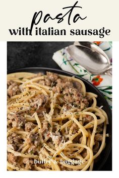 pasta with italian sausage in a skillet on top of a white and black plate