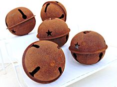 four chocolate donuts with black stars on them sitting on a white tray next to each other