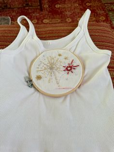 a white tank top with embroidery on it