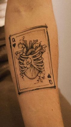 a tattoo on the arm of a man with a heart and flowers in it's center