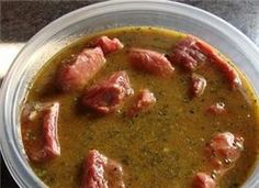 a bowl of soup with meat in it on a table