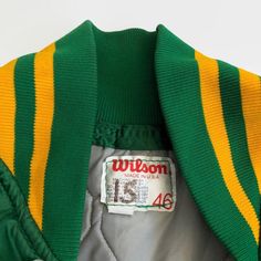 "You won't find many of these, a 1990s game used Pocatello Gate City Pioneers jacket. The green nylon jacket features \"PIONEERS\" constructed on the front chest in yellow. The sleeve cuffs, collar and waist are elastic with green-yellow-green. The jacket features two front pockets. A \"Wilson\" manufacturer's size 46 label is stitched on the inside collar. Features - Color: green and yellow - Sewn on tackle twill graphics - \"Pioneers\" on the front - Metal button up front - Green-yellow-green Gate City, Minor League Baseball, Baseball Jacket, Green And Yellow, Small Chest, Metal Buttons, Hat Sizes, Piece Of Clothing, Green Yellow